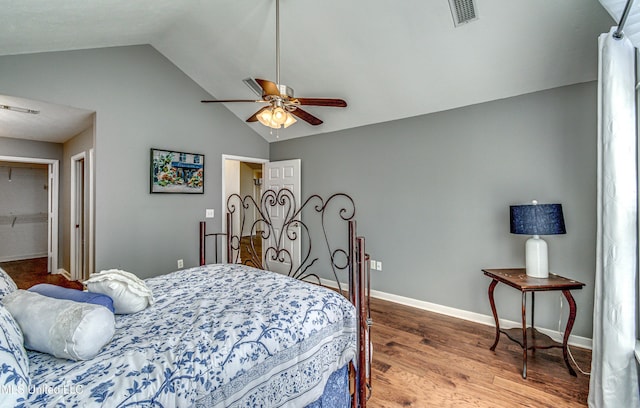 bedroom featuring baseboards, visible vents, a ceiling fan, lofted ceiling, and wood finished floors