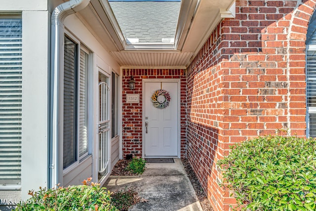 view of exterior entry featuring brick siding