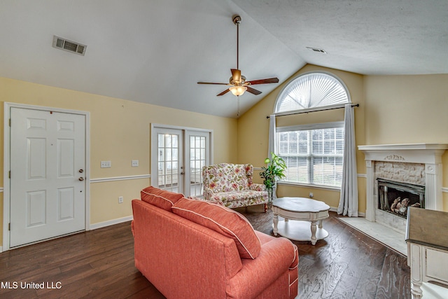 living room featuring a wealth of natural light, a fireplace, visible vents, and wood finished floors