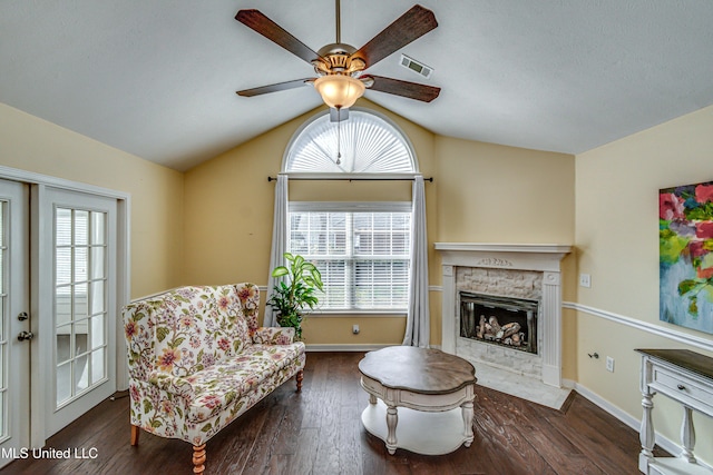 living area with wood-type flooring, visible vents, vaulted ceiling, and a healthy amount of sunlight