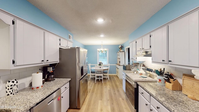 3902 S Windermere Dr, Nesbit, MS 38651 - kitchen featuring stainless steel appliances, under cabinet range hood, a textured ceiling, light wood finished floors, and white cabinets