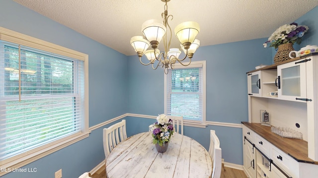 3902 S Windermere Dr, Nesbit, MS 38651 - dining area featuring a chandelier, light wood-style flooring, a textured ceiling, and baseboards