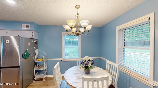 3902 S Windermere Dr, Nesbit, MS 38651 - dining room featuring a chandelier, light wood-style flooring, and a textured ceiling
