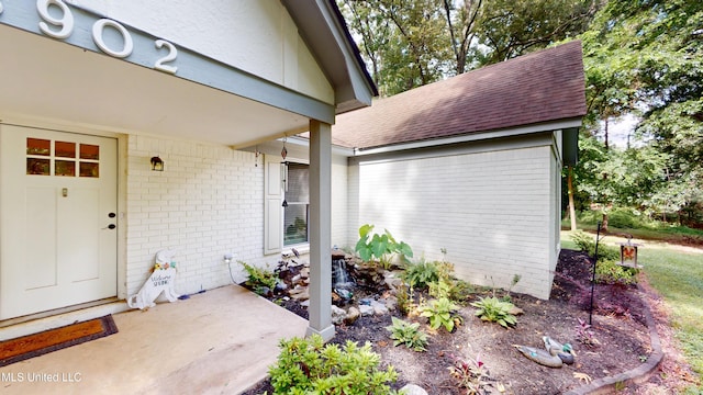 3902 S Windermere Dr, Nesbit, MS 38651 - view of exterior entry featuring brick siding, roof with shingles, and a patio