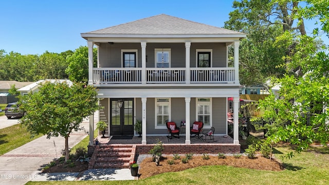 view of front of house with french doors, a porch, a balcony, and a shingled roof