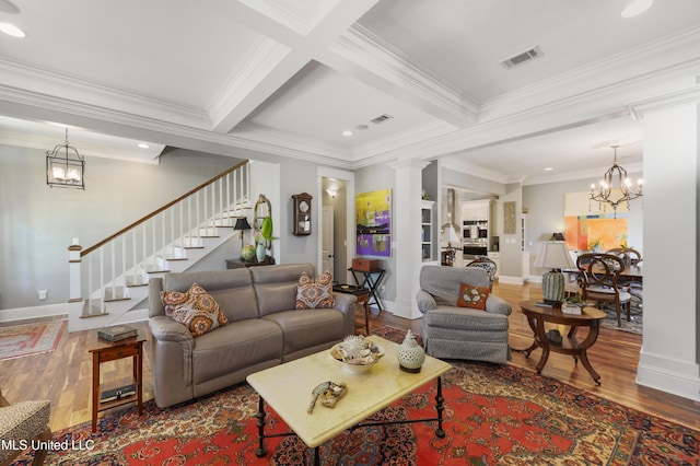 living room featuring a chandelier, wood finished floors, stairs, crown molding, and baseboards