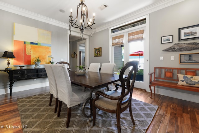 dining space featuring a chandelier, dark wood finished floors, and ornamental molding