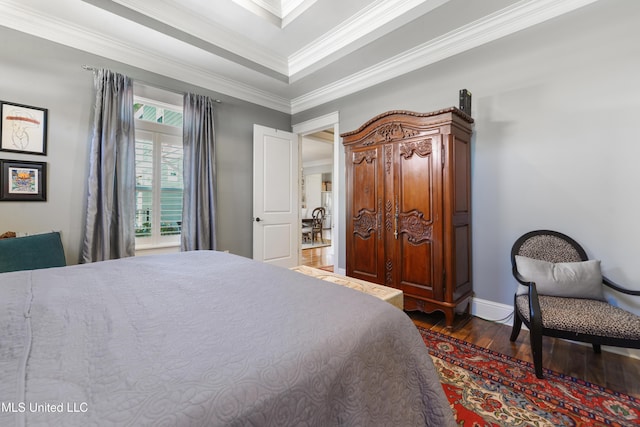 bedroom featuring dark wood-type flooring, ornamental molding, and baseboards