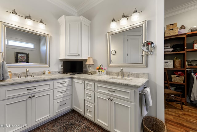 full bath featuring crown molding, double vanity, and wood finished floors