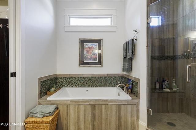 bathroom featuring a stall shower and a garden tub