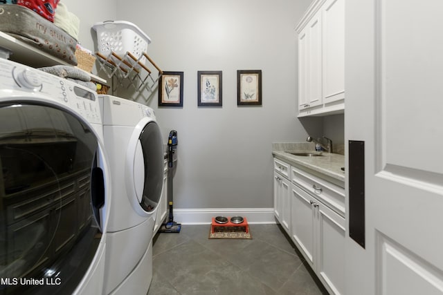 laundry area featuring separate washer and dryer, cabinet space, baseboards, and dark tile patterned floors