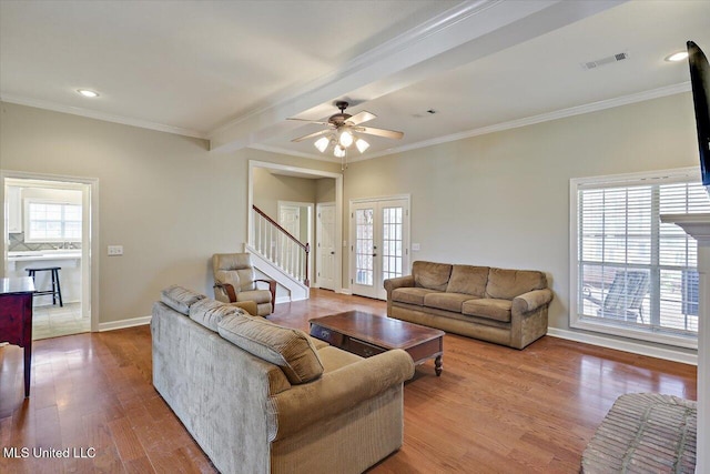 living area with plenty of natural light, visible vents, wood finished floors, and french doors