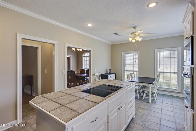 kitchen featuring crown molding, visible vents, tile counters, and black electric cooktop