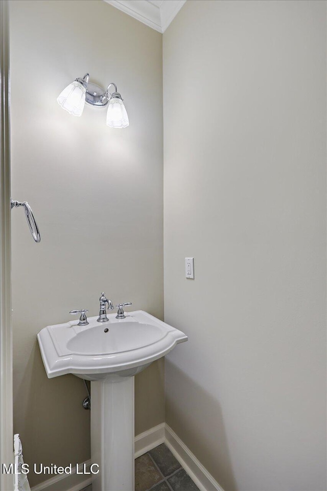 bathroom featuring ornamental molding and baseboards