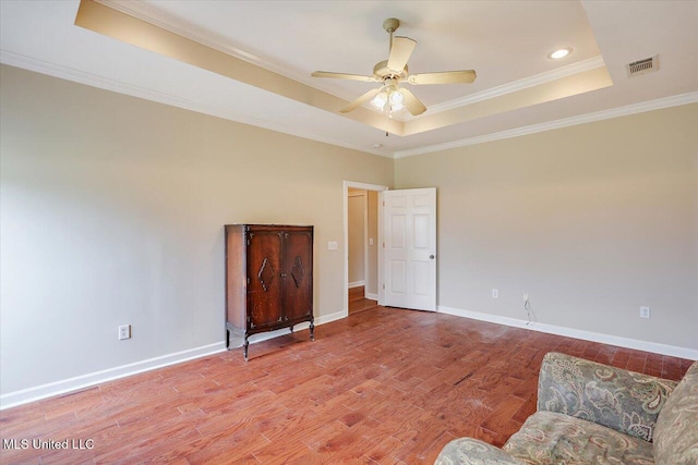 unfurnished room featuring baseboards, a raised ceiling, visible vents, and light wood-style floors