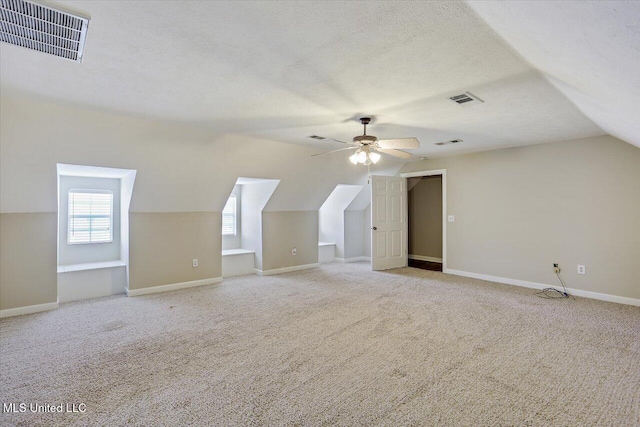 bonus room with a textured ceiling, carpet, and visible vents