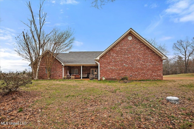 exterior space with brick siding and a lawn