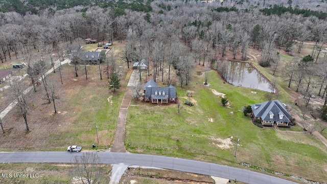 birds eye view of property featuring a water view, a wooded view, and a rural view