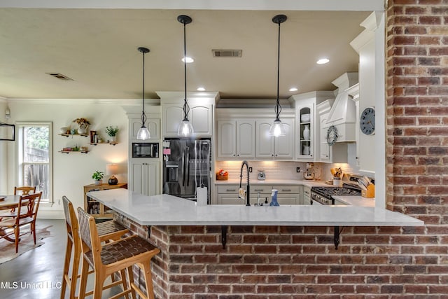 513 Willow Valley Cir, Brandon, MS 39047 - kitchen with black appliances, crown molding, light countertops, a peninsula, and tasteful backsplash
