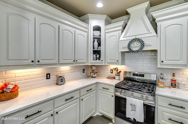 513 Willow Valley Cir, Brandon, MS 39047 - kitchen featuring stainless steel gas range, white cabinets, glass insert cabinets, and decorative backsplash