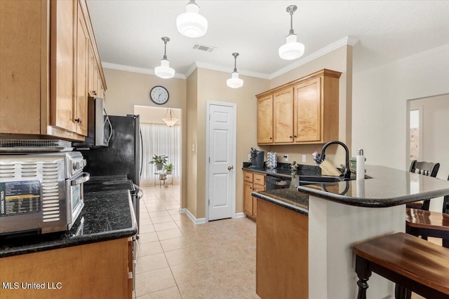 kitchen with hanging light fixtures, crown molding, a breakfast bar, light tile patterned floors, and appliances with stainless steel finishes