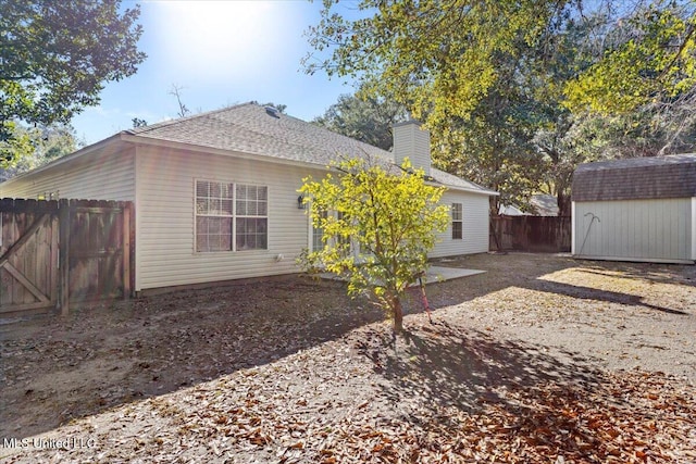 rear view of house featuring a storage unit