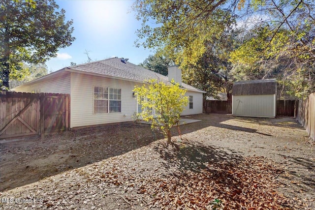 back of house featuring a storage unit