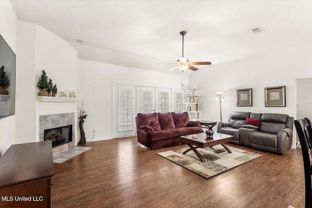 living room featuring a fireplace, dark hardwood / wood-style flooring, vaulted ceiling, and ceiling fan