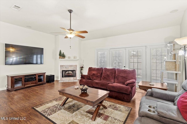 living room with hardwood / wood-style floors, ceiling fan, a fireplace, and french doors