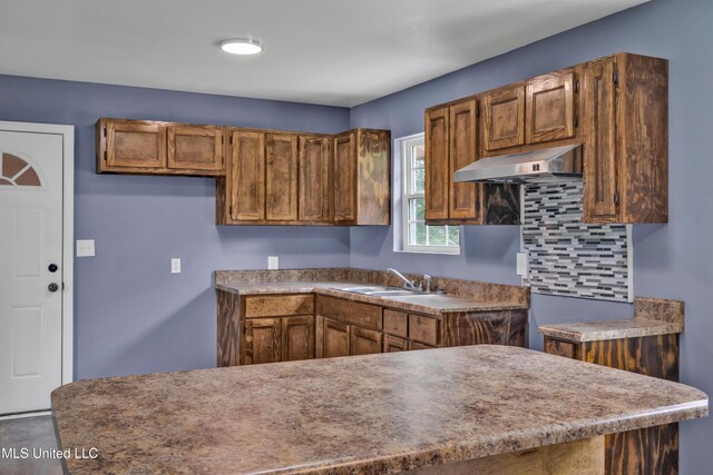 2713 Brazil St, Pascagoula, MS 39581 - kitchen with a sink, brown cabinetry, and under cabinet range hood