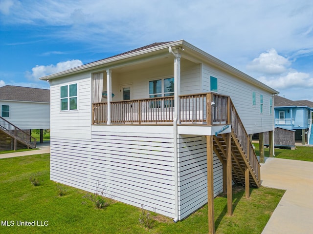view of front of house with a wooden deck, stairs, and a front yard