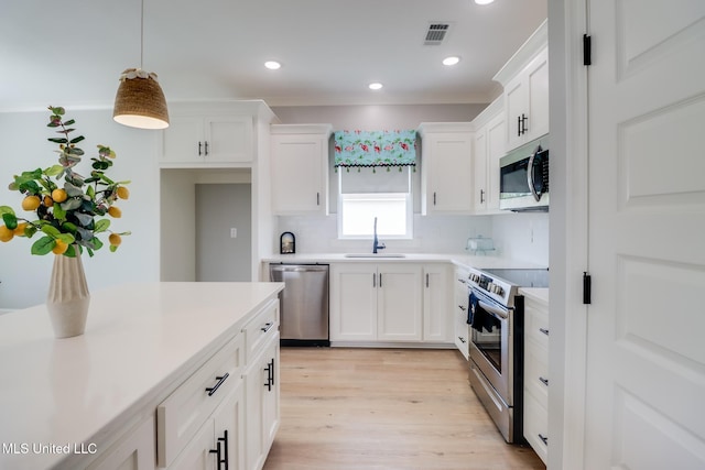 kitchen featuring visible vents, recessed lighting, white cabinetry, a sink, and stainless steel appliances