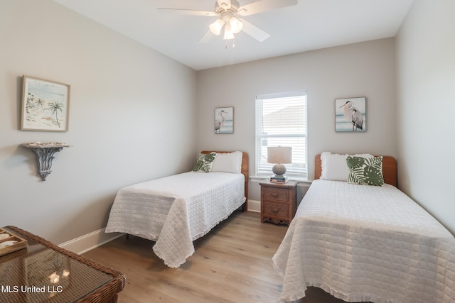 bedroom with light wood-style floors, a ceiling fan, and baseboards