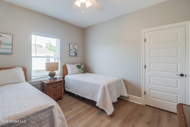 bedroom with baseboards, ceiling fan, and wood finished floors