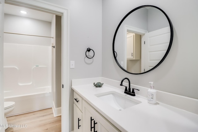 bathroom with vanity, shower / tub combination, wood finished floors, and toilet