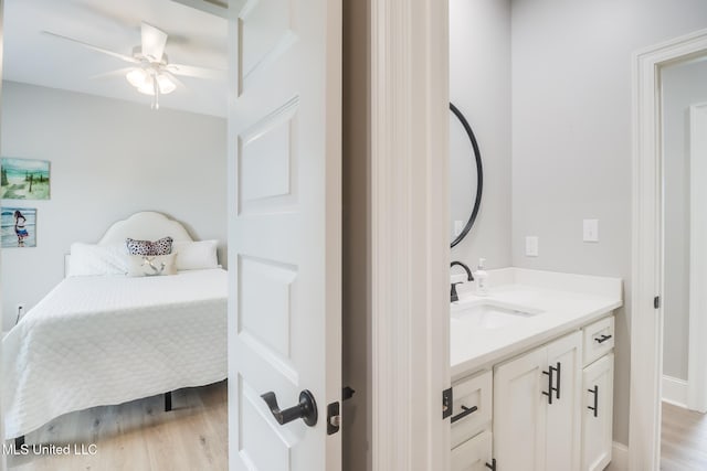 bathroom featuring vanity, ceiling fan, wood finished floors, and connected bathroom