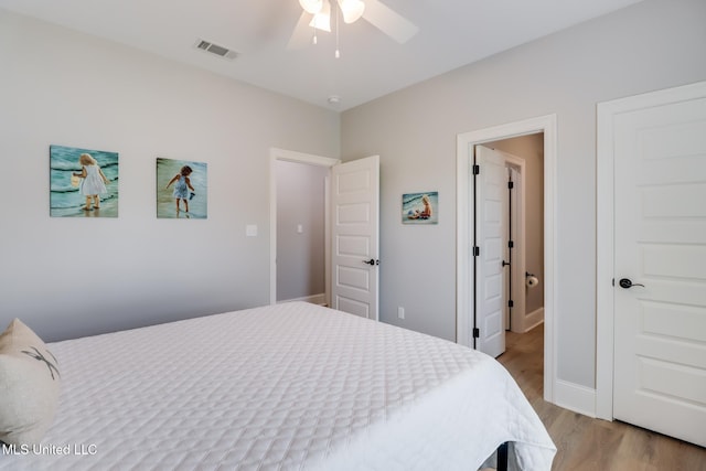 bedroom with light wood-style floors, baseboards, a ceiling fan, and visible vents
