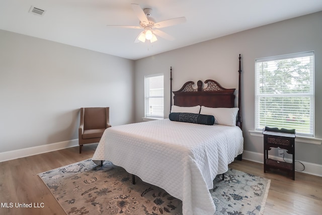 bedroom with multiple windows and wood finished floors