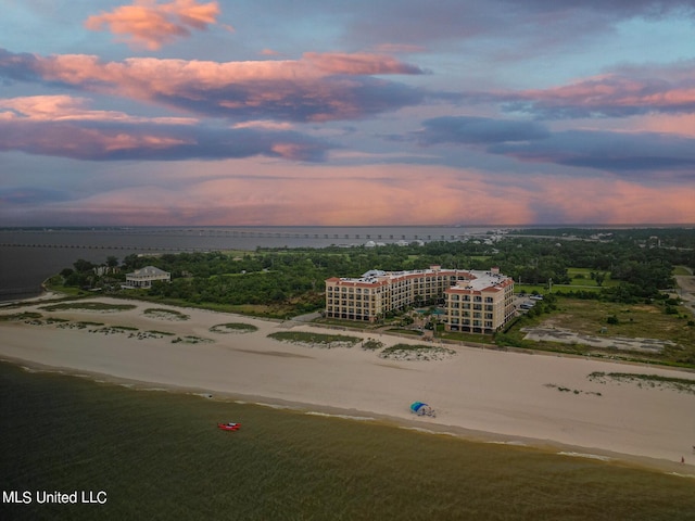 aerial view at dusk featuring a water view