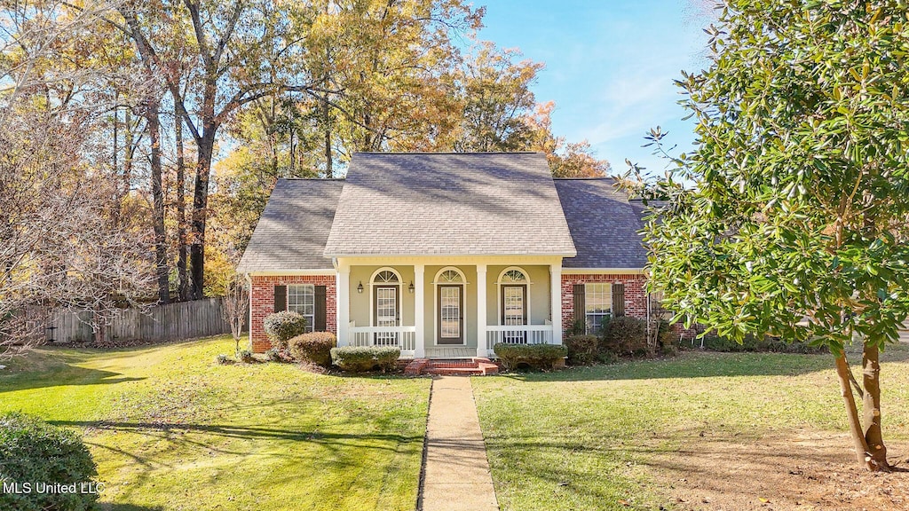 view of front of property with covered porch and a front yard