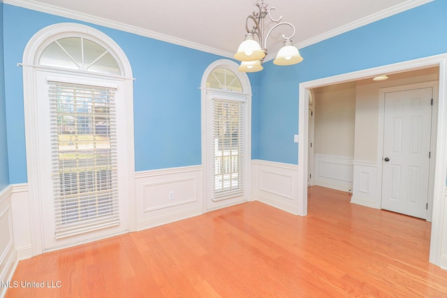 unfurnished dining area featuring a chandelier, light hardwood / wood-style flooring, and crown molding