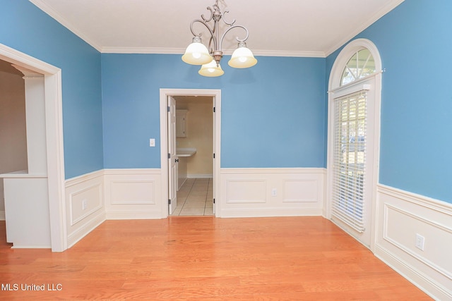 unfurnished dining area with ornamental molding, light hardwood / wood-style floors, and an inviting chandelier