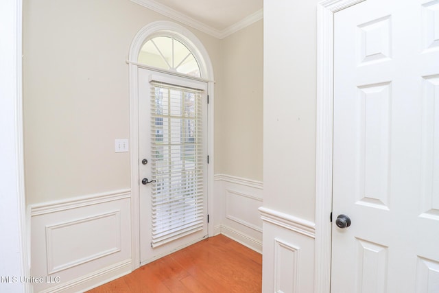 doorway to outside with hardwood / wood-style floors and ornamental molding