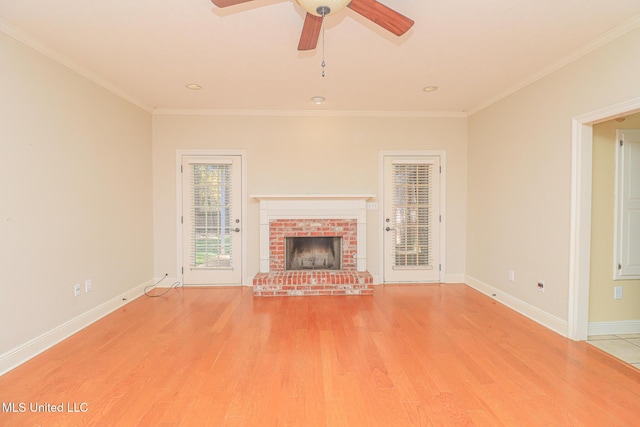 unfurnished living room featuring crown molding, a fireplace, ceiling fan, and light wood-type flooring