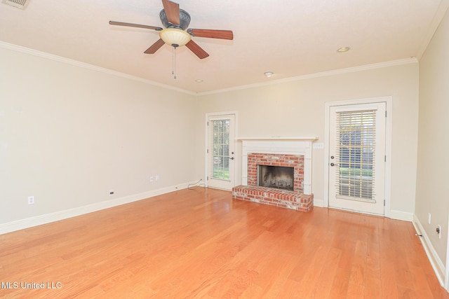 unfurnished living room featuring ceiling fan, ornamental molding, light hardwood / wood-style floors, and a brick fireplace