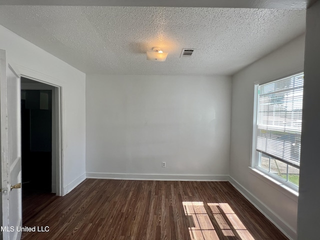 802 Farmer St, Cleveland, MS 38732 - spare room with dark wood-style floors, baseboards, and a textured ceiling