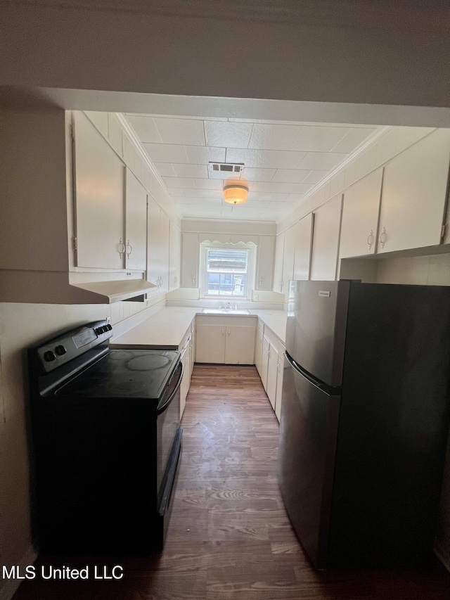 802 Farmer St, Cleveland, MS 38732 - kitchen with freestanding refrigerator, electric range, dark wood finished floors, white cabinets, and ornamental molding
