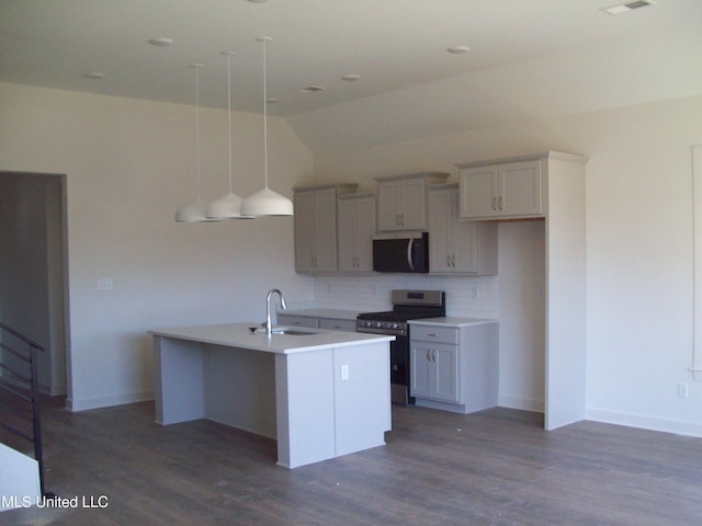 kitchen featuring sink, tasteful backsplash, dark hardwood / wood-style flooring, stainless steel range oven, and a center island with sink