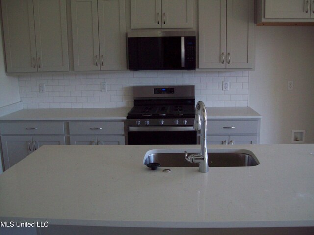 kitchen with stainless steel appliances, tasteful backsplash, and sink