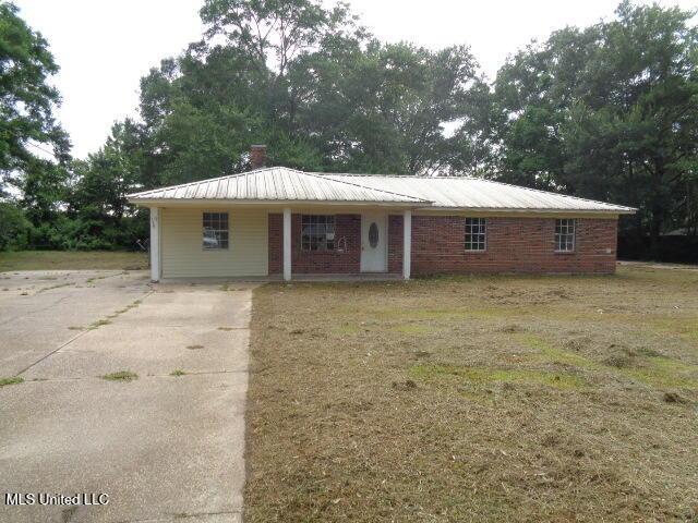 6301 Pioneer Trl, Moss Point, MS 39562 - view of front facade featuring a metal roof, concrete driveway, and brick siding